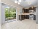 Bright kitchen with stainless steel appliances, dark cabinets, and sliding glass doors to the backyard at 2020 Greenwood Valley Dr, Plant City, FL 33563