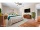 This virtually staged bedroom features sleek wood floors, modern decor, and warm, inviting colors at 2020 Greenwood Valley Dr, Plant City, FL 33563