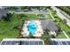 Aerial view of a community pool featuring a unique shape, surrounded by palm trees and a sunbathing area at 2020 Greenwood Valley Dr, Plant City, FL 33563