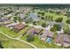 Lovely aerial view of a residential community with a golf course and a pond with blue sky and homes at 25950 Risen Star Dr, Wesley Chapel, FL 33544