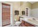 Bathroom with granite countertop, light wood cabinet, and door to the backyard at 25950 Risen Star Dr, Wesley Chapel, FL 33544