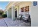 Inviting covered front porch with comfortable seating area on the brick-paved front of the home at 25950 Risen Star Dr, Wesley Chapel, FL 33544