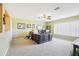 Large home office with carpet, an executive desk, a ceiling fan, and natural lighting at 25950 Risen Star Dr, Wesley Chapel, FL 33544