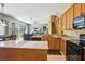 Open-concept kitchen with granite countertops, a breakfast bar, and a view of the adjacent Gathering room at 25950 Risen Star Dr, Wesley Chapel, FL 33544
