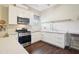 Bright kitchen featuring white cabinets, stainless steel appliances, and dark hardwood floors at 25950 Risen Star Dr, Wesley Chapel, FL 33544