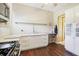 Charming kitchen featuring white cabinets, stainless steel appliances, and dark hardwood floors at 25950 Risen Star Dr, Wesley Chapel, FL 33544