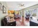 Spacious living area with hardwood floors, ceiling fan, and sliding glass doors to the outdoor patio at 25950 Risen Star Dr, Wesley Chapel, FL 33544