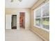 The main bedroom has neutral carpet, view of the outdoors, and ensuite bathroom access at 25950 Risen Star Dr, Wesley Chapel, FL 33544