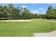 A sand volleyball court amidst a wide green lawn and trees, promoting active community recreation at 25950 Risen Star Dr, Wesley Chapel, FL 33544