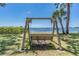 Bench overlooking the waterfront with tropical landscaping and a relaxing swing in the distance at 2700 Bayshore Blvd # 6210, Dunedin, FL 34698