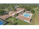 Aerial view of clubhouse featuring a large pool, tennis courts, and well-maintained landscaping at 2850 Doone Cir, Palm Harbor, FL 34684