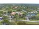 Aerial view of community amenities featuring a swimming pool, tennis courts, and clubhouse amidst lush greenery at 2850 Doone Cir, Palm Harbor, FL 34684