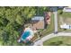 Aerial view showcasing a community pool and clubhouse nestled among lush greenery and a quiet street at 2850 Doone Cir, Palm Harbor, FL 34684