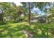 Spacious backyard with lush greenery and mature trees, offering privacy and shade at 2850 Doone Cir, Palm Harbor, FL 34684