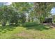 Lush backyard with verdant lawn, mature trees, and a cozy seating area for outdoor enjoyment at 2850 Doone Cir, Palm Harbor, FL 34684
