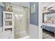 Bathroom featuring a glass enclosed walk-in shower, white wainscoting, and tile flooring at 2850 Doone Cir, Palm Harbor, FL 34684