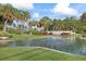 Picturesque Highland Lakes community entrance with lush landscaping and pond with fountain at 2850 Doone Cir, Palm Harbor, FL 34684