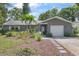 Charming single-story home featuring lush landscaping, a garage, and inviting front entry at 2850 Doone Cir, Palm Harbor, FL 34684