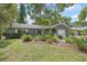 Charming single-story home featuring lush landscaping, a garage, and inviting front entry at 2850 Doone Cir, Palm Harbor, FL 34684