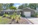 Charming single-story home featuring lush landscaping, a garage, and inviting front entry at 2850 Doone Cir, Palm Harbor, FL 34684