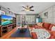 Relaxing living room showcasing wood floors, ceiling fan and an entertainment center with large-screen TV at 2850 Doone Cir, Palm Harbor, FL 34684