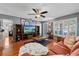 Inviting living room featuring wood floors, a ceiling fan, and comfortable seating arrangement at 2850 Doone Cir, Palm Harbor, FL 34684