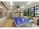 Spacious recreation room featuring tile floors, lockers, a ping pong table, and serene lake views at 2850 Doone Cir, Palm Harbor, FL 34684