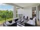 Cozy outdoor balcony featuring comfortable seating, a striped rug, and a view of lush greenery at 2903 Cordoba Ranch Blvd, Lutz, FL 33559