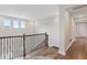 Upstairs hallway showcasing wood floors, natural light from windows, and wrought iron railing at 2903 Cordoba Ranch Blvd, Lutz, FL 33559
