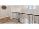 Upstairs hallway featuring wood floors, iron railing, trim accents, and natural light from the windows at 2903 Cordoba Ranch Blvd, Lutz, FL 33559
