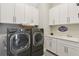 Modern laundry room showcasing a gray washer and dryer, white cabinets, counter space, and sink at 2903 Cordoba Ranch Blvd, Lutz, FL 33559