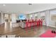Large living room with hardwood floors, red barstools, entertainment center, and windows with natural light at 2903 Cordoba Ranch Blvd, Lutz, FL 33559