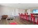 Spacious living area featuring hardwood floors, red bar stools, and an inviting seating area at 2903 Cordoba Ranch Blvd, Lutz, FL 33559