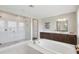 Bright bathroom with a soaking tub, double vanity, and a glass-enclosed shower featuring white tile and a rain shower at 2903 Cordoba Ranch Blvd, Lutz, FL 33559