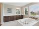 Bright bathroom with a soaking tub, white tile floors, and espresso vanity with double sinks and countertop space at 2903 Cordoba Ranch Blvd, Lutz, FL 33559