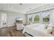 Bright main bedroom features a tray ceiling, hardwood floors, sitting area, and large windows with wooded views at 2903 Cordoba Ranch Blvd, Lutz, FL 33559