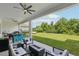 Covered patio with ceiling fans, outdoor seating, fire pit, BBQ, and expansive backyard at 2903 Cordoba Ranch Blvd, Lutz, FL 33559