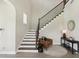 Staircase with wood steps, iron railing, natural light, and stylish decor table and chair at 2903 Cordoba Ranch Blvd, Lutz, FL 33559