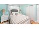 Bedroom with light blue walls, wood floors, and white furniture, including a beautifully dressed queen bed at 2960 59Th S St # 215, Gulfport, FL 33707