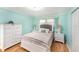 Bedroom with light blue walls, wood floors, and white furniture, including a beautifully dressed queen bed at 2960 59Th S St # 215, Gulfport, FL 33707