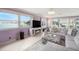 Cozy living room showcasing large windows with a waterfront view, modern fireplace, and comfortable seating area at 2960 59Th S St # 215, Gulfport, FL 33707