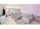 Bright living room with an oversized sectional couch, patterned ottoman, tile floors, and a view of the water at 2960 59Th S St # 215, Gulfport, FL 33707