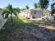 Fenced backyard with palm trees, a small platform, and a wooden playset with room for outdoor activities at 310 4Th Ave. Southwest, Ruskin, FL 33570