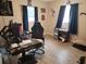 Functional bedroom with hardwood floors, a large desk, a comfortable gaming chair, and natural light from two windows at 310 4Th Ave. Southwest, Ruskin, FL 33570