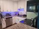Modern kitchen with white cabinets, granite countertops, stainless steel appliances, and blue under-cabinet lighting at 310 4Th Ave. Southwest, Ruskin, FL 33570