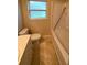 Bathroom features a toilet, bathtub, and window providing natural light at 3111 S Canal Dr, Palm Harbor, FL 34684