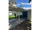 View of the carport with a peek at the home's facade and surrounding greenery under a bright sky at 3111 S Canal Dr, Palm Harbor, FL 34684