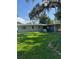 Charming single-story home featuring a well-maintained lawn and covered carport, shaded by mature trees at 3111 S Canal Dr, Palm Harbor, FL 34684