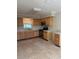 Well-lit kitchen featuring classic wood cabinetry, modern stainless steel appliances, and durable tile floors at 3111 S Canal Dr, Palm Harbor, FL 34684
