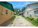 Driveway between residential homes with a wheelbarrow, flowers, and a blue sky at 312 E Tomlin St, Plant City, FL 33563